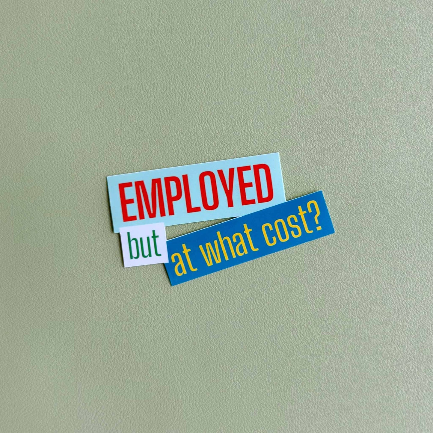 Close-up of the 'Employed but at what cost?' vinyl sticker in light blue, white, and green