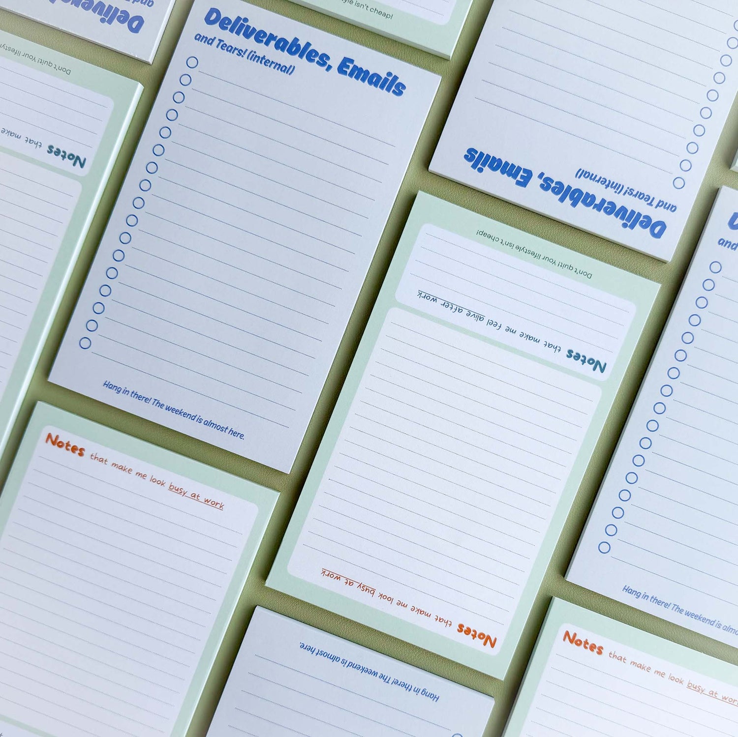Several 'Deliverables, Emails and Tears (internal)' and 'Notes (that make me look busy at work)' notepads laid out in an overlapping grid pattern.