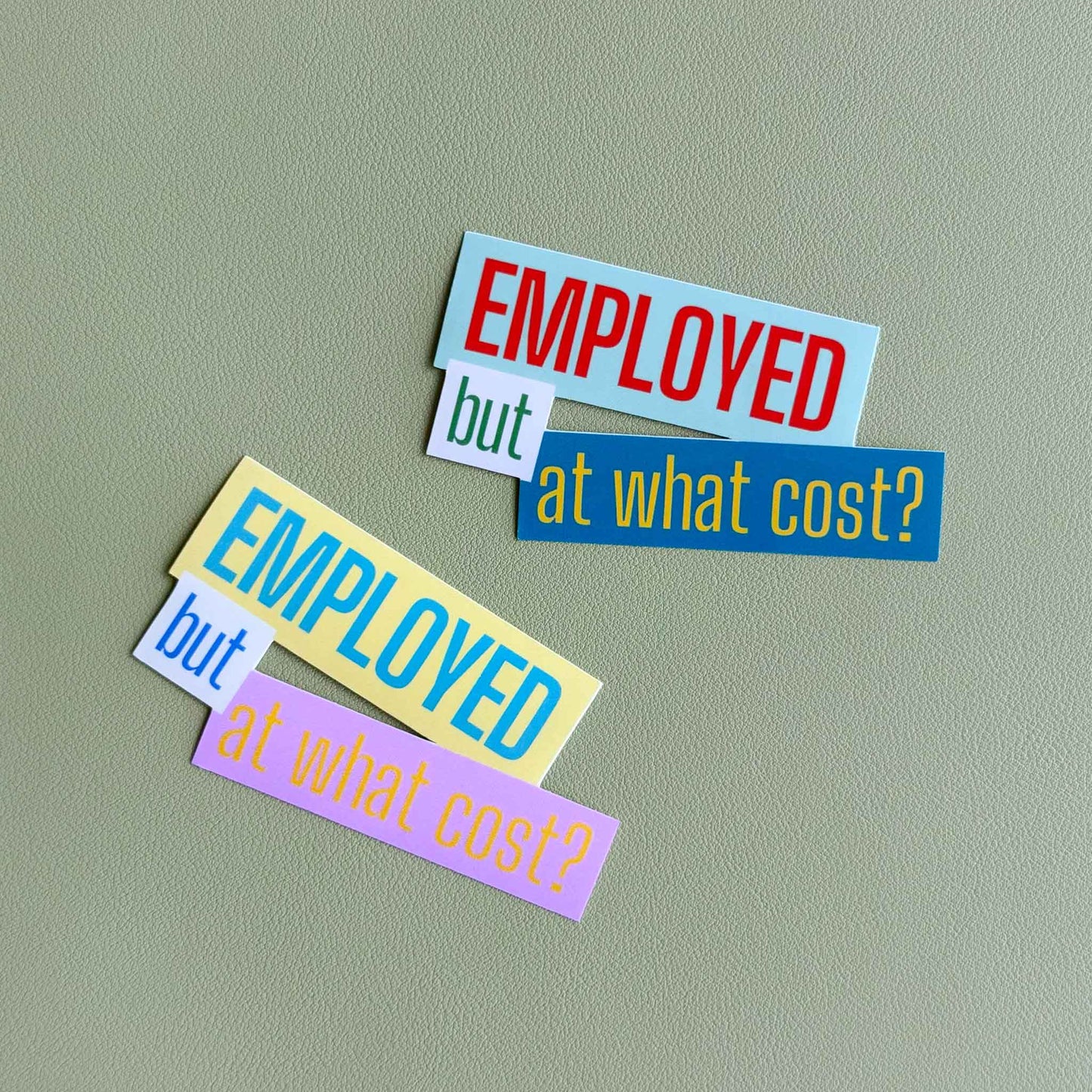 Two 'Employed but at what cost?' vinyl stickers shown side by side in different colorways — one in light blue, white, and green, the other in yellow, white, and pink