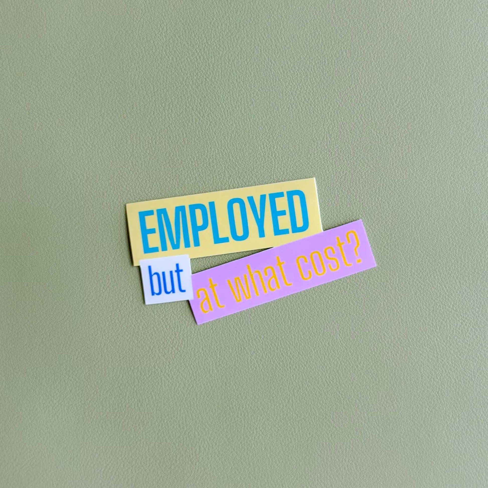 Close-up of the 'Employed but at what cost?' vinyl sticker in yellow, white, and pink