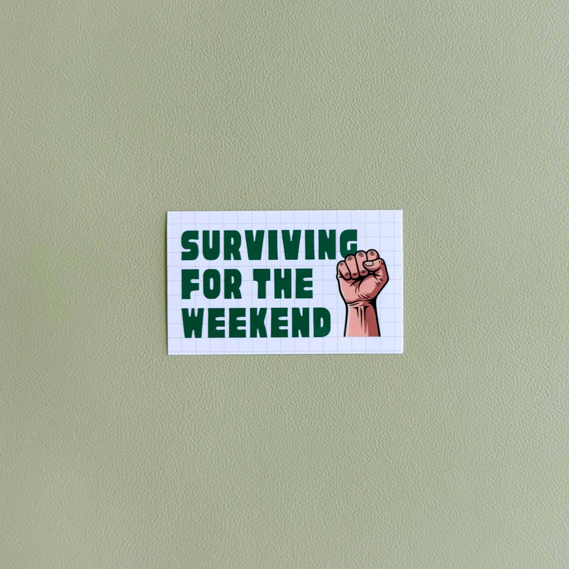 Vinyl sticker that reads 'Surviving for the Weekend' in a bold retro font with a raised fist illustration