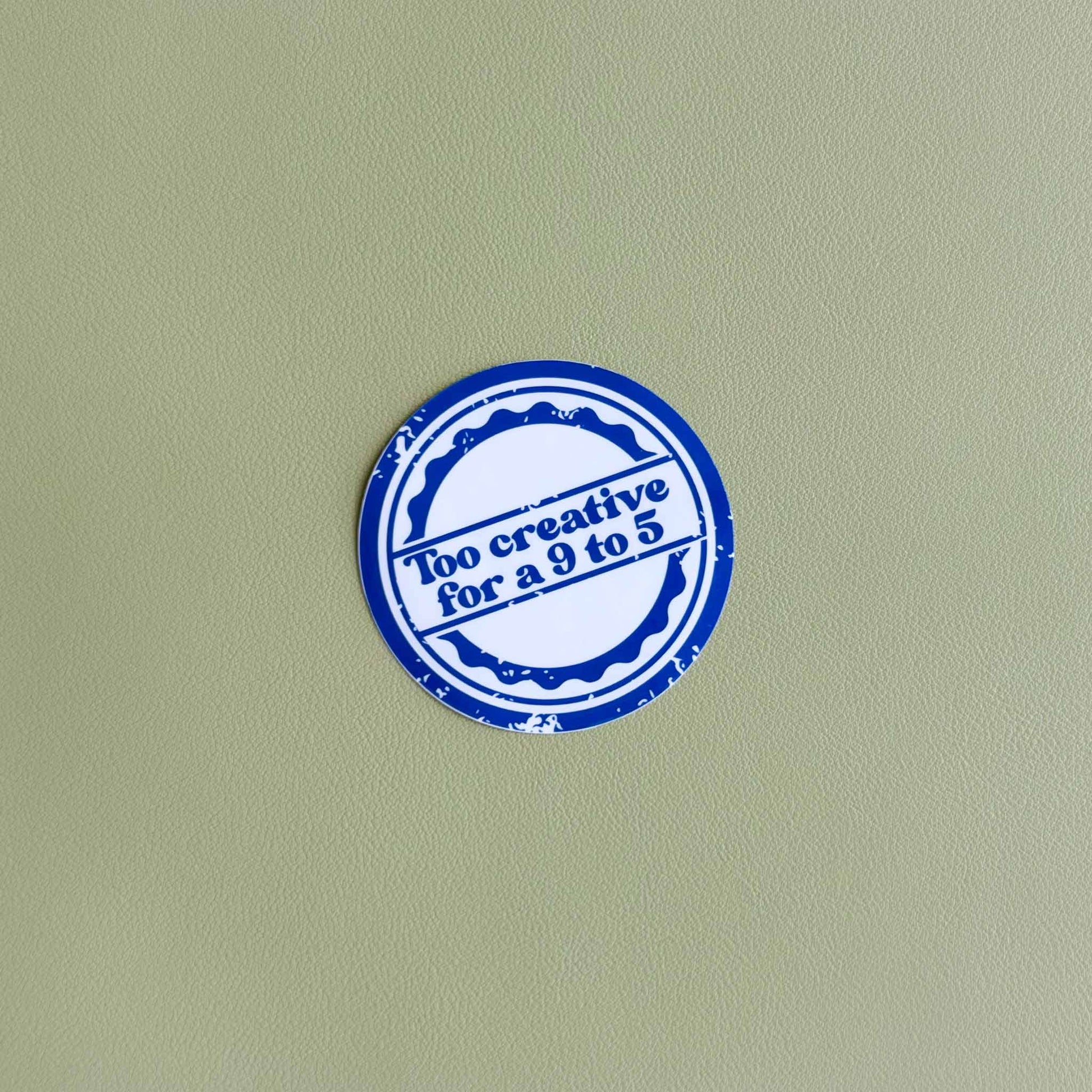 Round vinyl sticker with 'Too creative for a 9 to 5' in white text inside a blue stamp-style circle